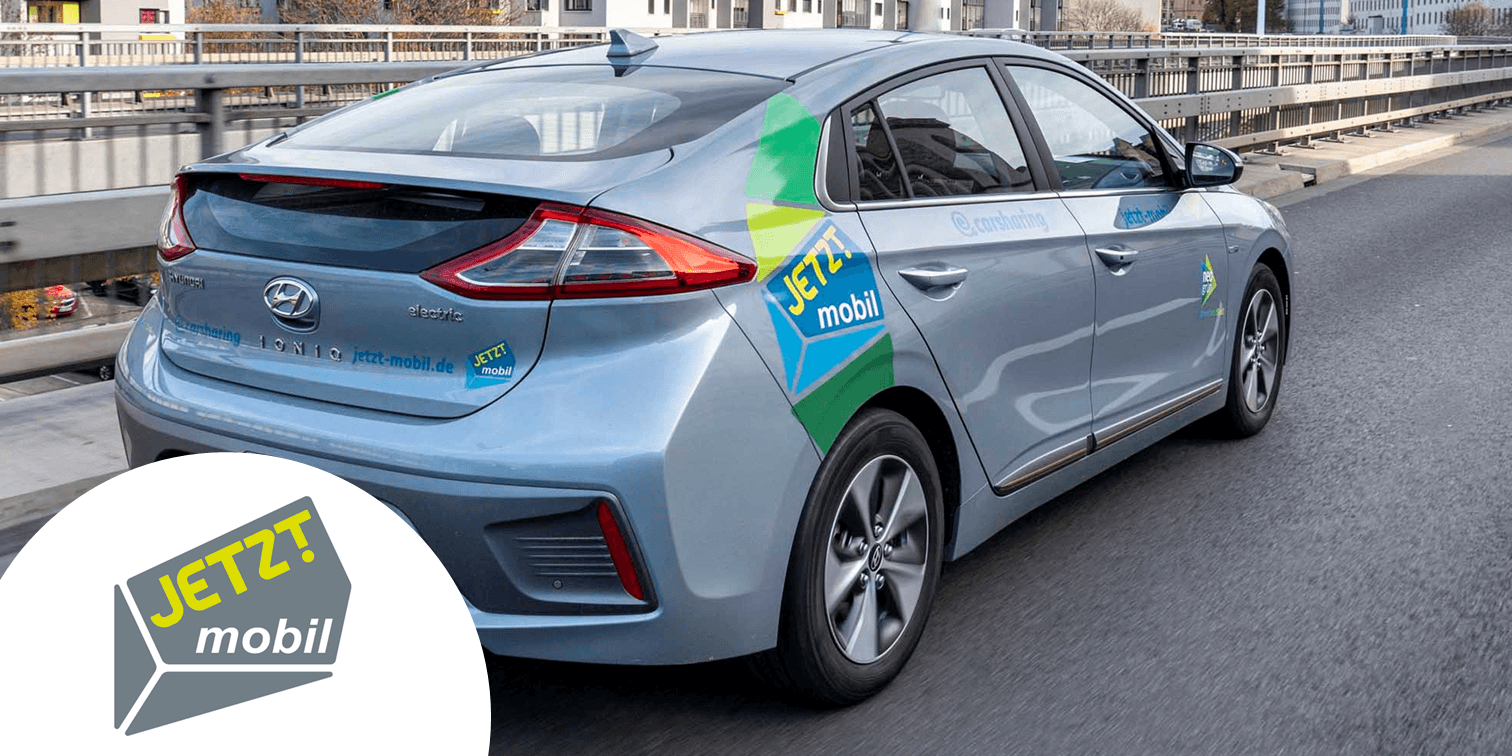 Silver car and logo of the carsharing partner Jetzt Mobil.