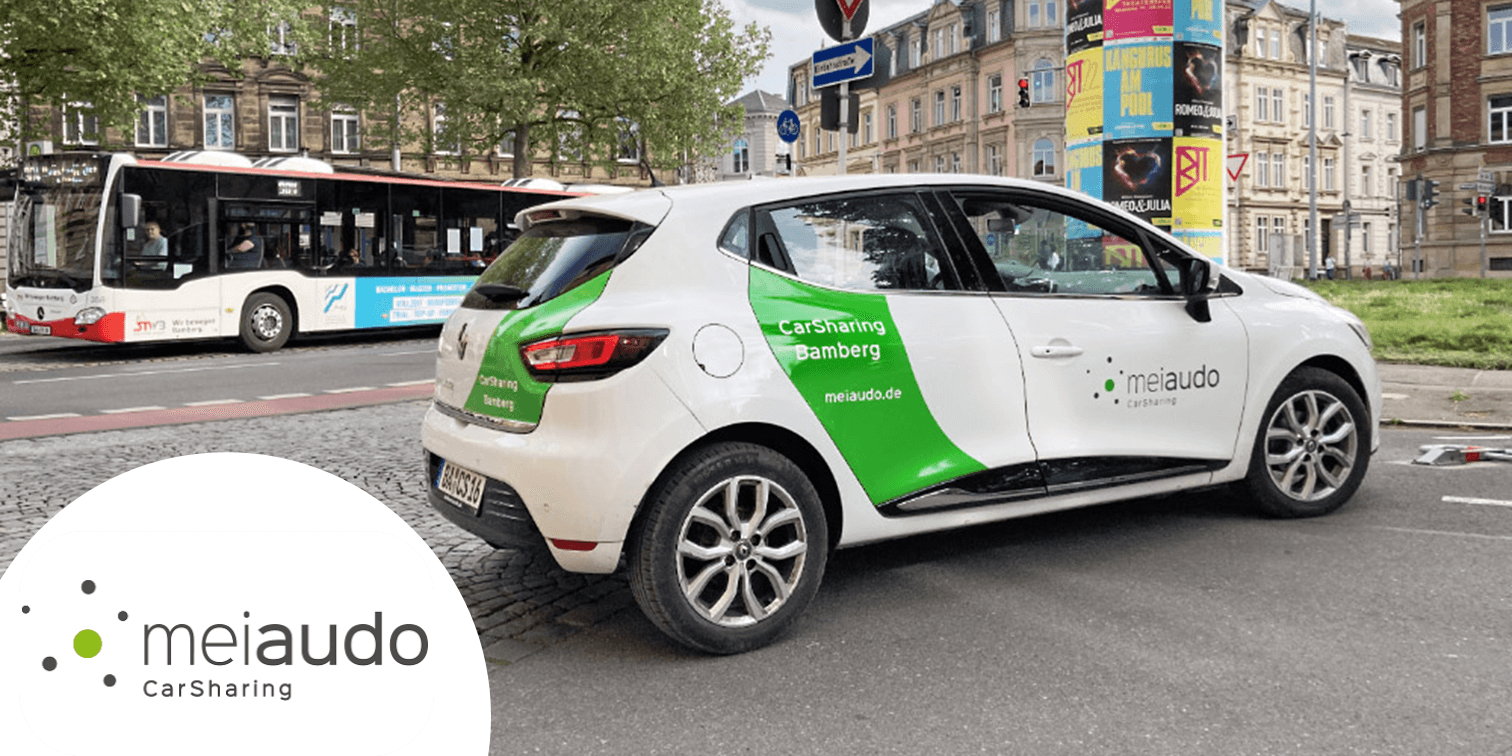 White-green car and logo of the carsharing partner meiaudo.