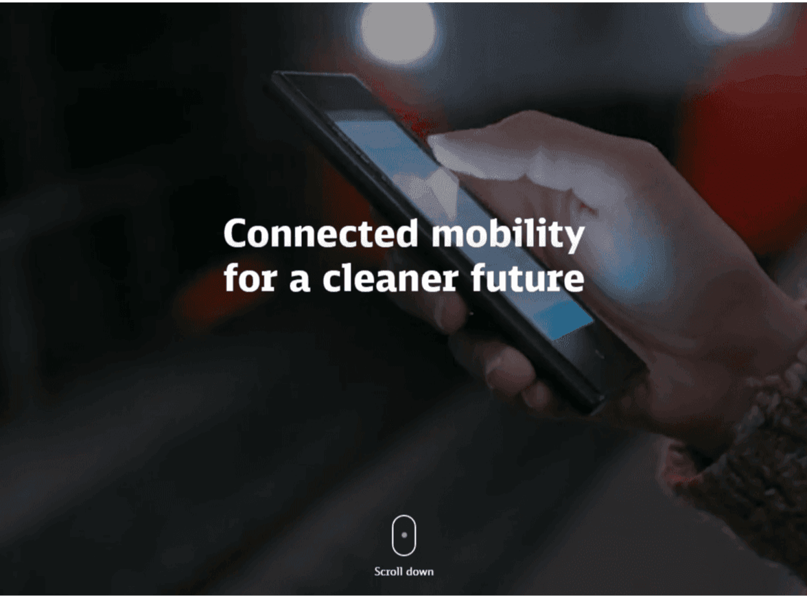 One hand holds a smartphone with the text 'Connected mobility for a cleaner future' in the foreground.