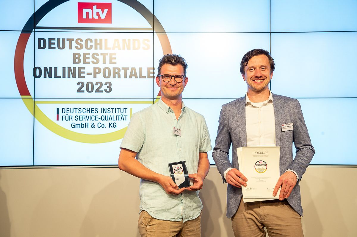 Teamleiter und Abteilungsleiter halten eine Urkunde und einen Preis für Deutschlands beste Online-Portale 2023. copyright Thomas Ecke / DISQ / ntv