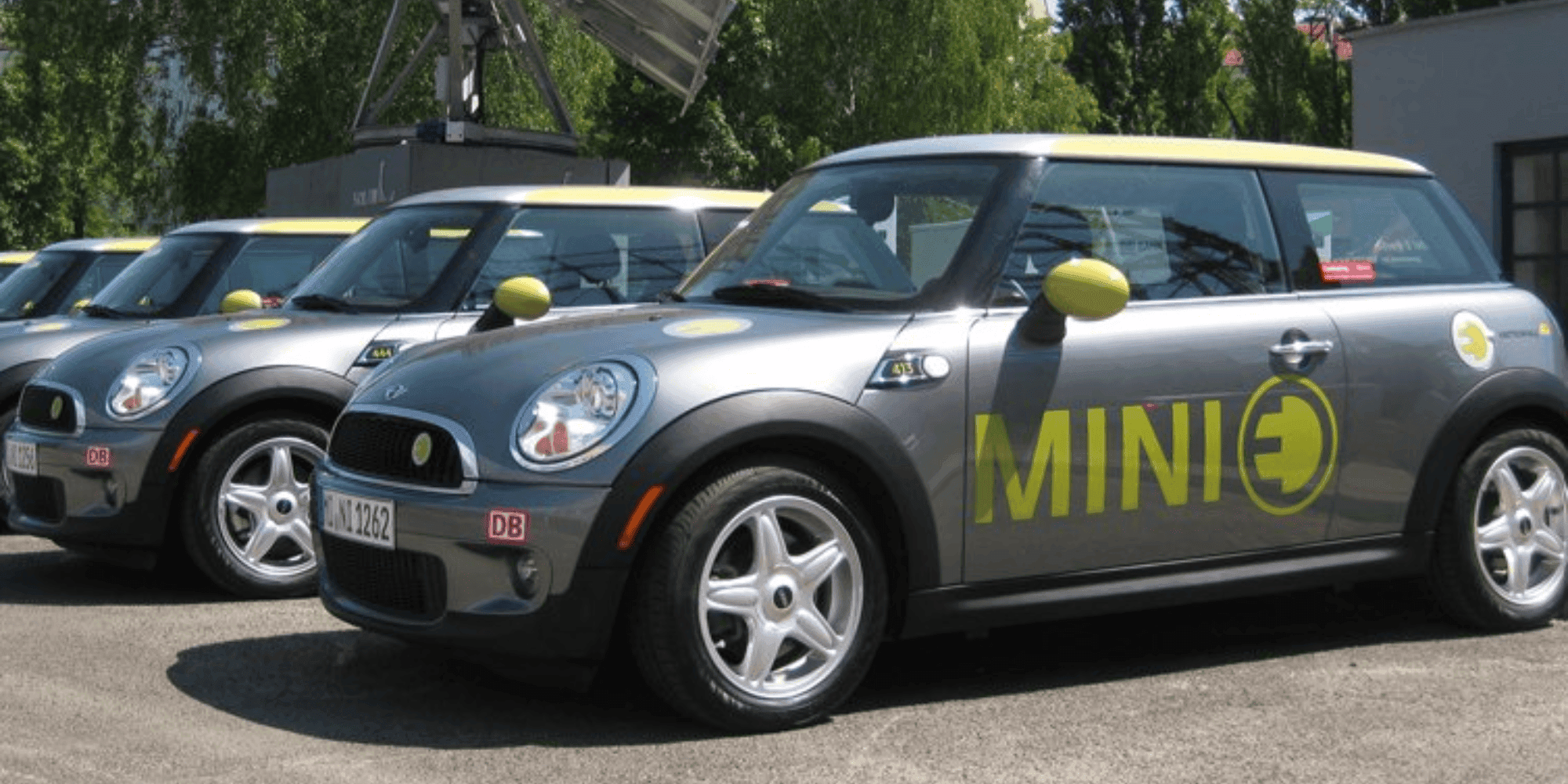 Eine Reihe von silbernen Mini E Autos mit DB-Logo.
